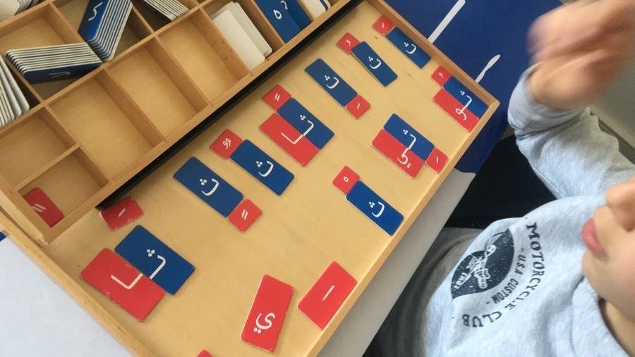 Un enfant travaille seul avec un plateau de lettres